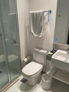 a bathroom with a toilet and a shower and a sink at Quarto com acabamento superior no Design Hotel Linhares in Linhares