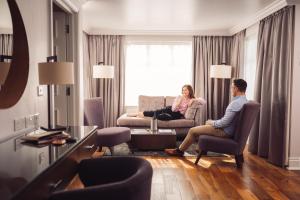 a man and woman sitting in a living room at Ivanhoe Inn and Hotel in Belfast