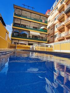 ein Gebäude mit einem Swimmingpool vor einem Gebäude in der Unterkunft Apartamento Hidalgo in Puerto de la Cruz
