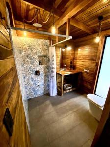 Hojancha的住宿－Hoja Azul - Sustainable teak modern cabin in Hojancha，客房内设有带水槽和卫生间的浴室