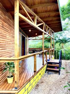 Hojancha的住宿－Hoja Azul - Sustainable teak modern cabin in Hojancha，房屋设有木甲板和长凳