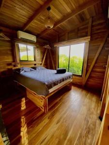 Hojancha的住宿－Hoja Azul - Sustainable teak modern cabin in Hojancha，小木屋内一间卧室,配有一张床