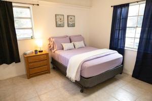 a small bedroom with a bed and a night stand at Sheikra Retreat Economy Room in Tampa