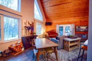 a living room with a wooden ceiling with windows at Corporate Cabin Aurora Refuge in Fairbanks