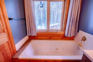 a bath tub in a bathroom with a window at Corporate Cabin Aurora Refuge in Fairbanks +47 photos