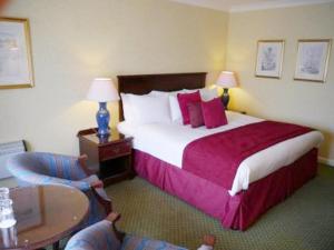 a hotel room with a large bed and a table at Urban Hotel in Grantham