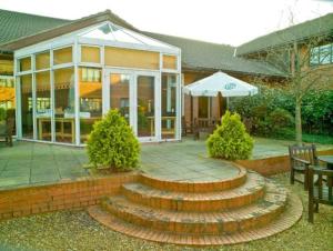 a house with a patio with stairs and an umbrella at Urban Hotel in Grantham
