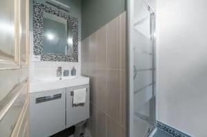 a bathroom with a sink and a shower with a mirror at ⟬La Maisonnette de Séverine⟭ in Saint-Genès-Champanelle +12 photos