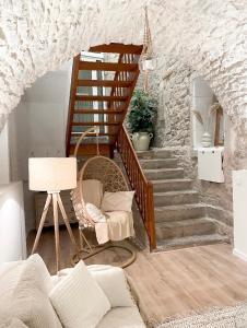 a room with a staircase with a chair and a couch at La voute Doloise - Love room & spa in Dole