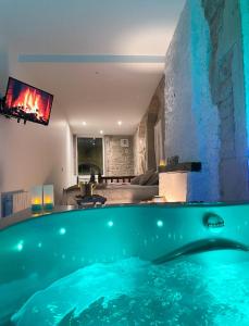 una piscina en una sala de estar con chimenea en La voute Doloise - Love room & spa en Dole