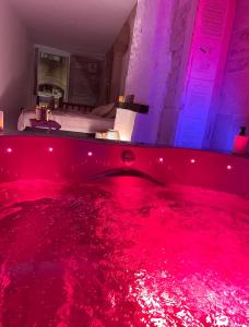 une chambre avec une baignoire remplie de sang rouge dans l'établissement La voute Doloise - Love room & spa, à Dole