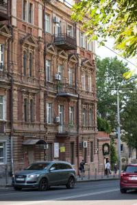 a green car parked in front of a large building at apartments on Chkalova in Dnipro