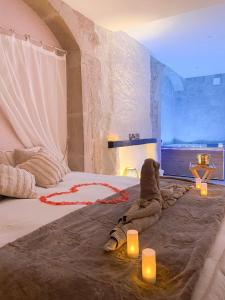 Un dormitorio con una cama grande con velas. en La voute Doloise - Love room & spa, en Dole