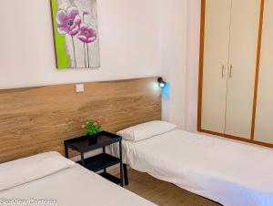 ラスパルマス・デ・グランカナリアにあるSeaview Canterasのベッド2台、テーブル(花付)が備わる客室です。