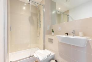 een badkamer met een douche, een wastafel en een toilet bij The Hackney Studio Apartments in Londen