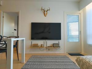 ein Wohnzimmer mit einem Flachbild-TV an der Wand in der Unterkunft Syöte Panorama in Syöte