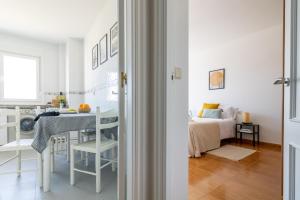 a white apartment with a bedroom and a table and a bed at Senel Home in Boimorto