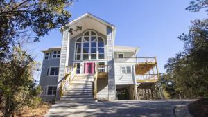 a house with stairs leading up to it at Oceanside, Pool, Hot Tub, Close to Beach, OH1, Silver Sandcastle in Corolla