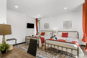 2 camas en una habitación con paredes blancas en Charming 2 BR Home in Philadelphia, Ideal Location, Ample Parking! en Filadelfia