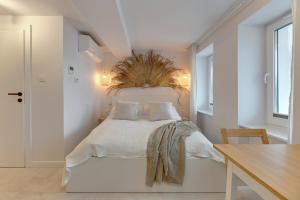 um quarto branco com uma cama com cabeceira de cama em Kamień by Grand Apartments em Gdynia
