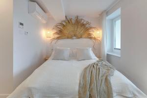 um quarto com uma cama branca e uma grande cabeceira de cama. em Kamień by Grand Apartments em Gdynia