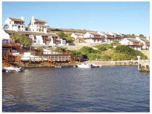 a large building on the water with boats in it at Breede River Lodge in Witsand +5 photos
