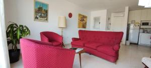 uma sala de estar com dois sofás vermelhos e uma mesa em Departamento ubicado en Viedma Centro. Amplio, comodo y confortable. em Viedma