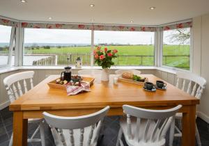 a dining room with a table and chairs and a window at Bwthyn y Ddol - a cottage with stunning views in Cardigan +14 photos