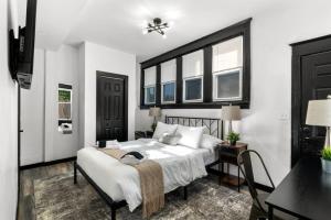 um quarto com uma cama, uma secretária e janelas em Modern City Luxury Home with Ample Parking in Charming Philly! em Filadélfia