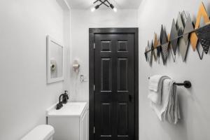 baño con aseo y puerta negra en Modern City Luxury Home with Ample Parking in Charming Philly!, en Filadelfia 29 fotos más