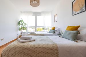 a white bedroom with two beds and a window at Senel Home in Boimorto