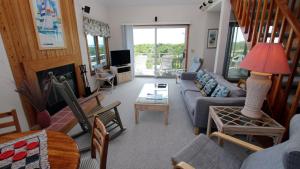 una sala de estar con un sofá y una mesa en Oceanside, 6 BRs, Private Pool, Ocean Views, Foosball, O2, Topside, en Duck