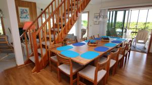 una mesa de comedor con sillas y una escalera en Oceanside, 6 BRs, Private Pool, Ocean Views, Foosball, O2, Topside, en Duck