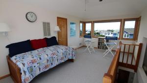 Un dormitorio con una cama y un reloj en la pared. en Oceanside, 6 BRs, Private Pool, Ocean Views, Foosball, O2, Topside, en Duck 24 fotos más