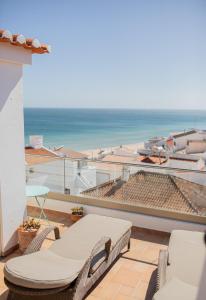 een balkon met stoelen en uitzicht op het strand bij Casa Pedro in Salema - Oceanview & beach in Salema