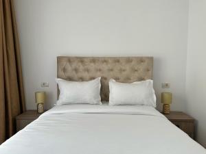 a bedroom with a large white bed with two lamps at KOA - Family Crib in Braşov