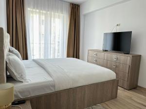 a bedroom with a bed with a television on a dresser at KOA - Family Crib in Braşov
