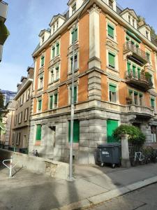 un gran edificio de ladrillo con ventanas verdes en una calle en City Home Zurich en Zúrich