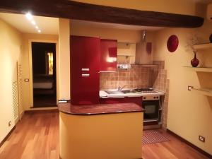 una cucina con armadi rossi e piano di lavoro di La Casa dei Fieschi a Lavagna