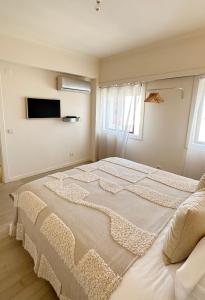 duże białe łóżko w pokoju z oknem w obiekcie Groovy Caparica Gem with Large Sunny Terrace w Costa de Caparica