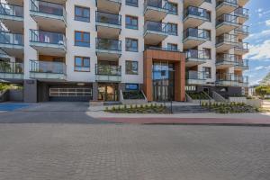 a large apartment building with a driveway at Rent like home - Bel Mare F324 in Międzyzdroje