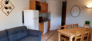 a living room with a couch and a table and a kitchen at Les Cristallines - Appartement Cosy in Orcières
