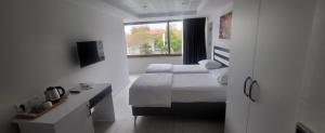 um quarto de hotel com duas camas e uma janela em MEYDAN BUTİK OTEL em Tekirdağ