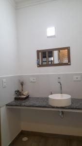 a bathroom counter with a sink and a mirror at Chalés Manacá da Serra in Ubatuba