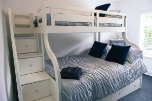 a bedroom with bunk beds with a bed and shelves at 4 bedroom - Sleep 9 home in Cheadle Staffordshire - Alton towers Polar Express Dimmingsdale Peak District Trentham Gardens Water World in Cheadle