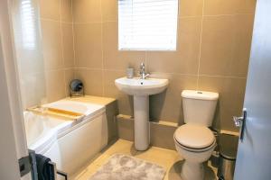 a bathroom with a toilet and a sink and a tub at 4 bedroom - Sleep 9 home in Cheadle Staffordshire - Alton towers Polar Express Dimmingsdale Peak District Trentham Gardens Water World in Cheadle +35 photos
