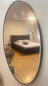 espejo que refleja un dormitorio con cama en una habitación en S&A apartamentai, en Panevėžys
