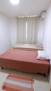 ein großes Bett in einem Zimmer mit Fenster in der Unterkunft Praia da Pérola in Ilhéus