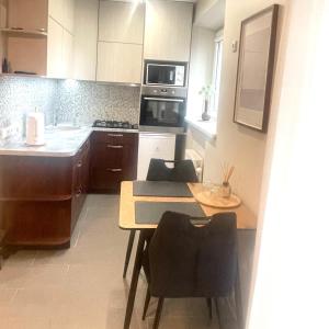 uma cozinha com uma mesa, cadeiras e um fogão em S&A apartamentai em Panevėžys