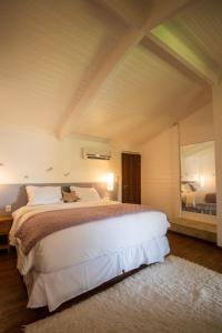 a bedroom with a large bed and a large mirror at Pousada Minha Louca Paixão in Morro de São Paulo